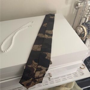 Fashion Tie with pearl necklace. Camouflage look.